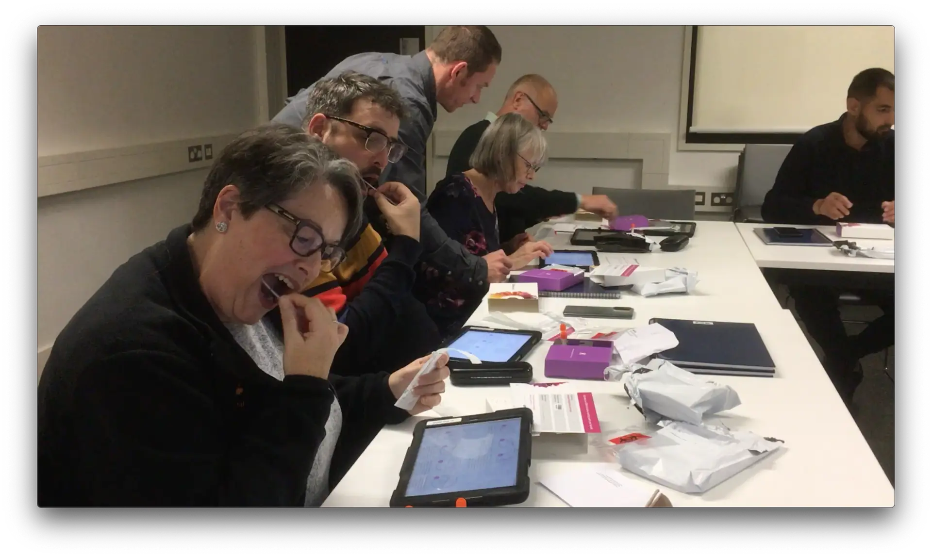 A group of community creatives swab their cheeks for a DNA test as part of the Ancestories project.