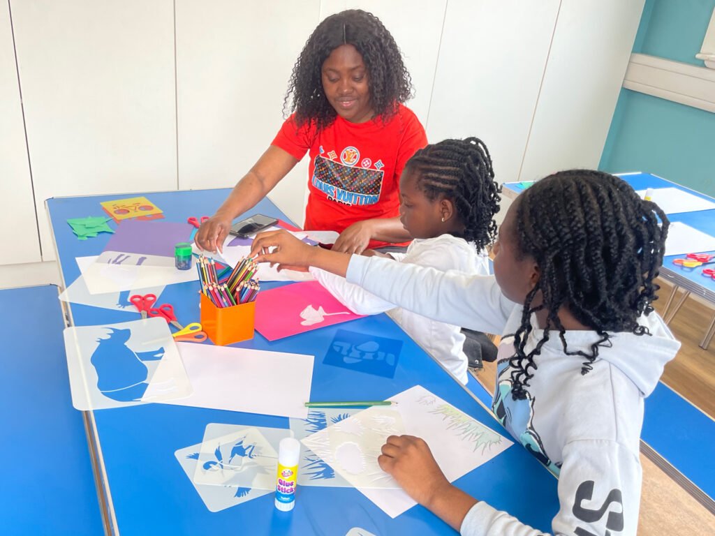 Three children doing paper collage as part of the Animates workshop